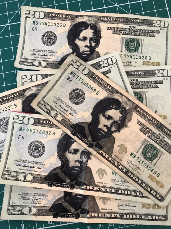 Many U.S. $20 bills that have had Harriet Tubman's face stamped over Andrew Jackson's in black ink.
